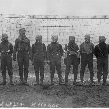 Gas mask-wearing British soldiers in front of a soccer goal in 1916