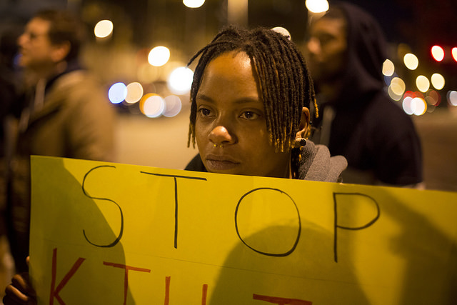 Photo of woman in Ferguson holding a "Stop Killing" poster on Nov. 25th