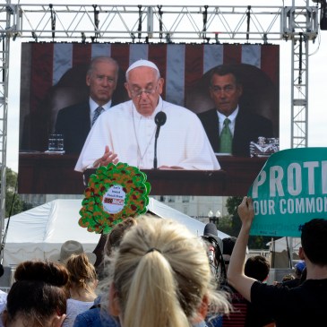 Environmental activists watch the Pope address Congress