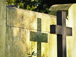Image of a cross casting a shadow on a grave