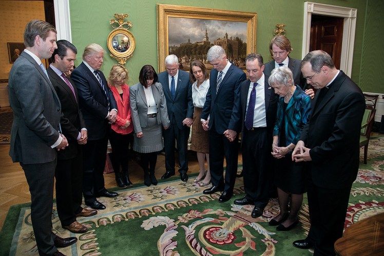 Donald Trump praying with others